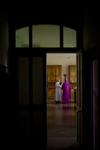 priest and bishop through a door 