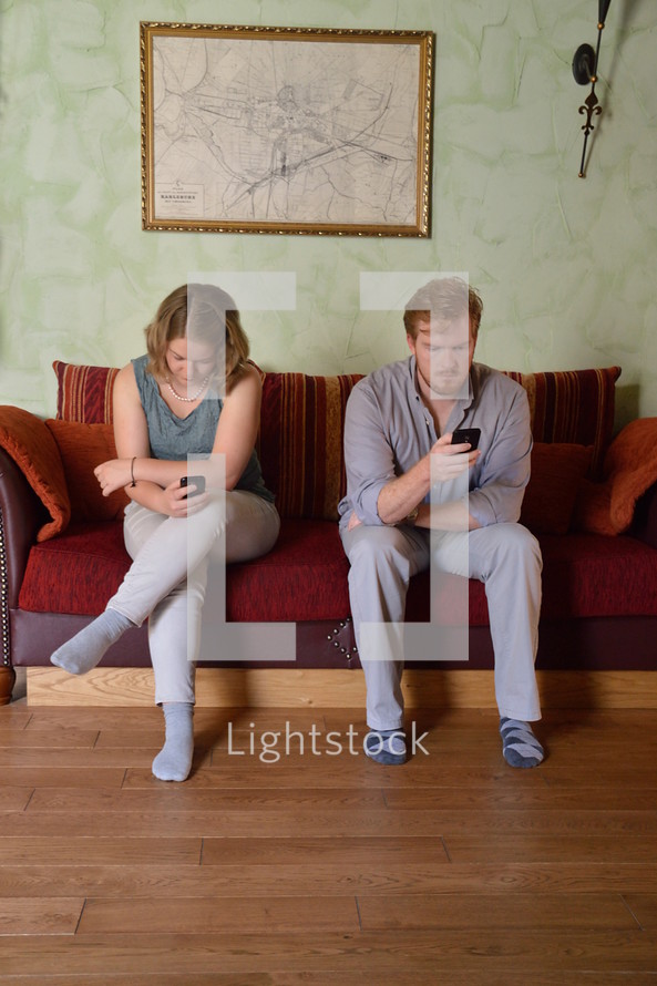 couple sitting on a sofa ignoring each other