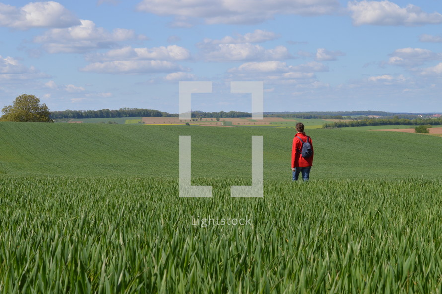 a woman standing in a corn field 