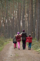 mother with her children on a stroll in the woods