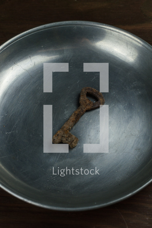 rusty key on an ancient pewter plate