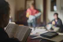 close up of young woman holding open her Bible  in a small group study