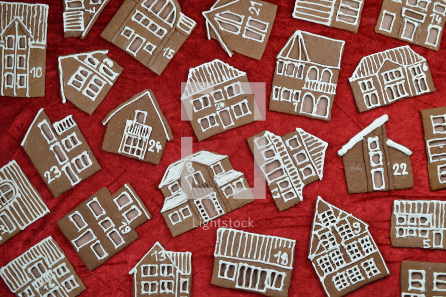 crisscross pattern out of 24 self baked different gingerbread houses on red as edible advent calendar