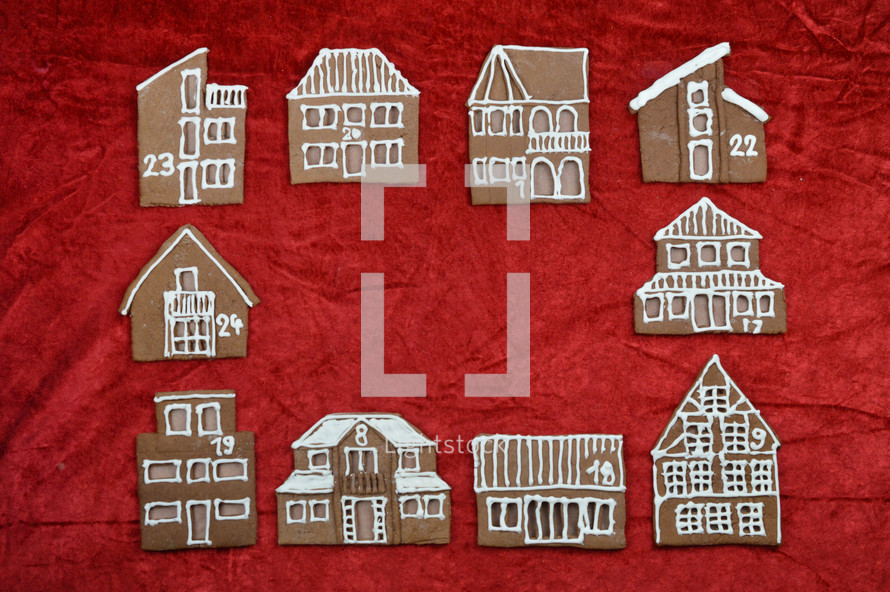 frame out of different self baked gingerbread houses on red with copy space in the middle as part of a advent calendar