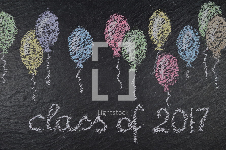 chalk on slate with balloons and the words: class of 2017
