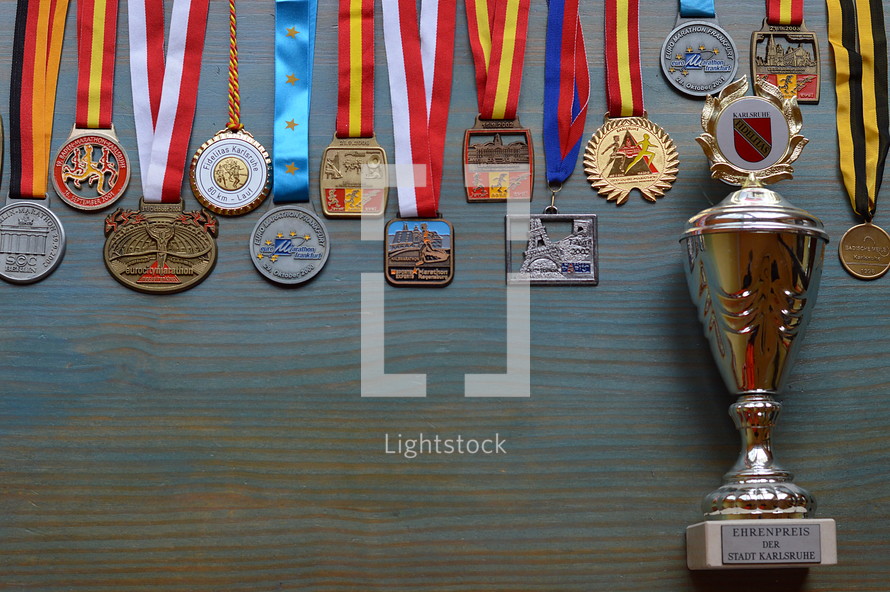medals and cup on cyan wooden background
