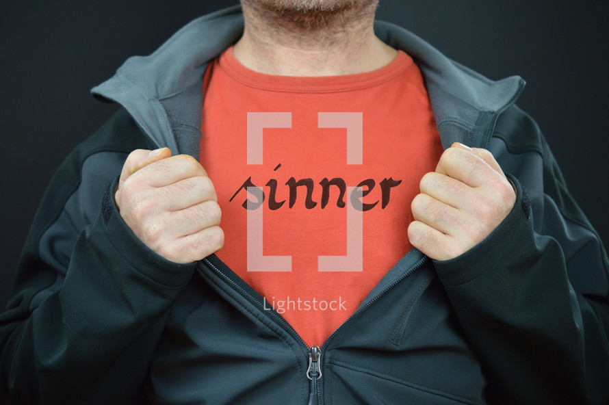 man showing his t-shirt with the word SINNER written on it