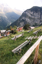 wooden benches along a steep mountainside 