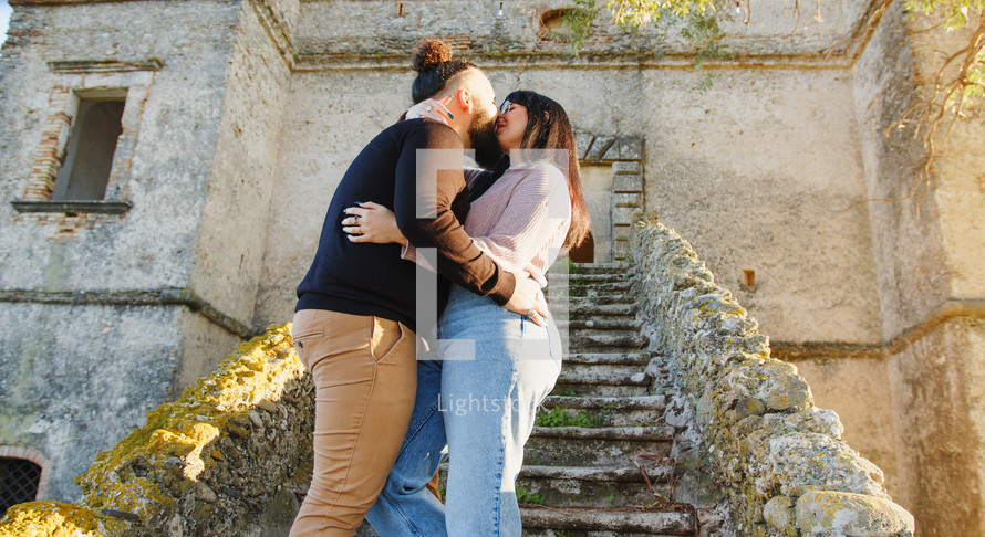 Couple love and kiss on the stairs of a castle during valentines day