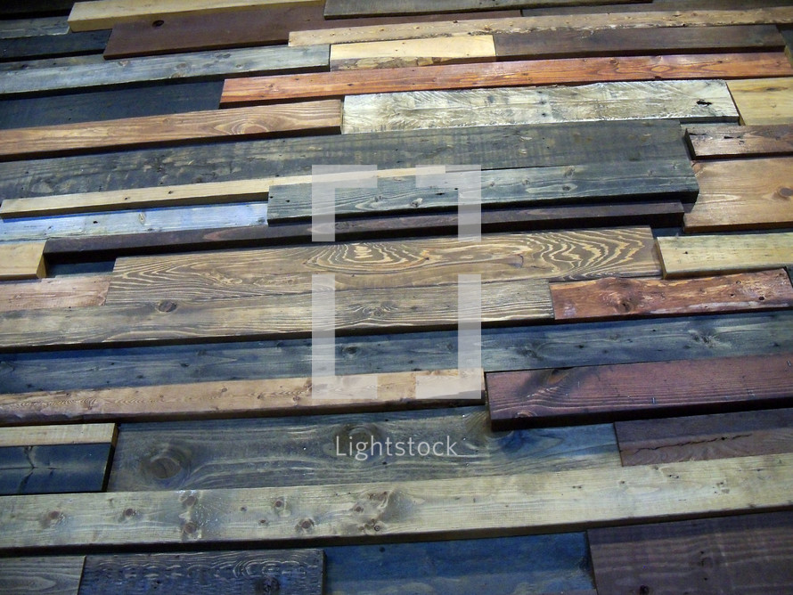 A wall of wood pieces showing different woods and wood patterns such as oak and pine to form a background of different wood grains, textures and color.