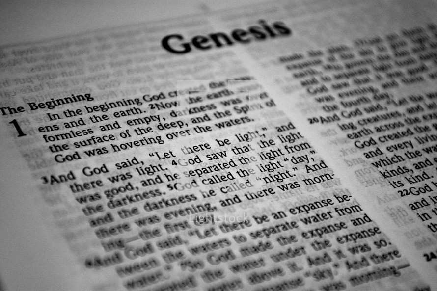 A Bible, open to the first page of Genesis.