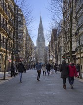 pedestrians in a city and view of a cathedral 