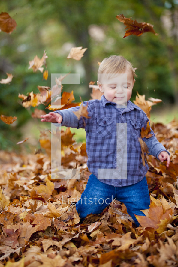 Toddler playing in the leaves