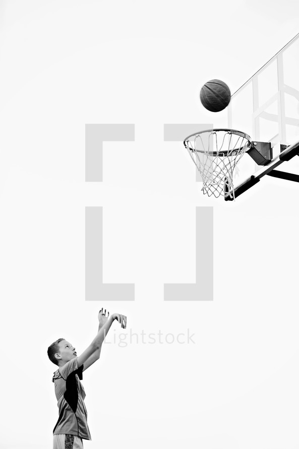 boy child shooting a basket playing basketball 