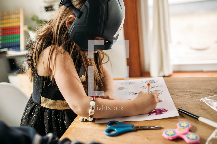 girl coloring on a coloring page at home 