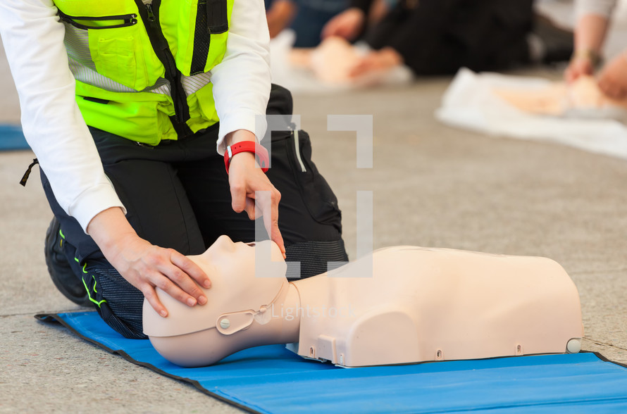 Female instructor showing CPR on training doll