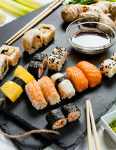 Black slate tray of assorted sushi and rolls