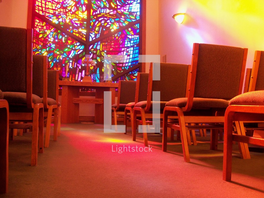 Church aisle and sunlight through a stained glass window 