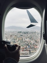 taking a picture of Nepal out a plane window 