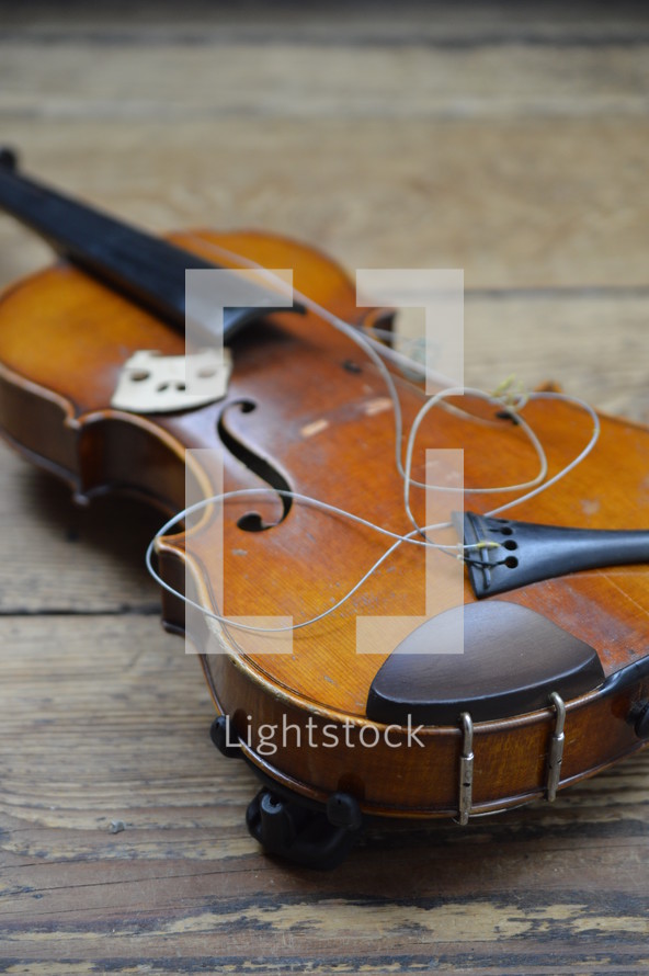 old broken violin on rural wooden floor
