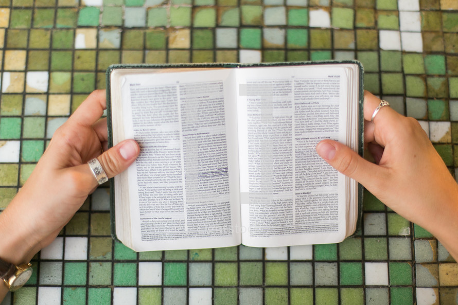 reading a Bible over a tile table 