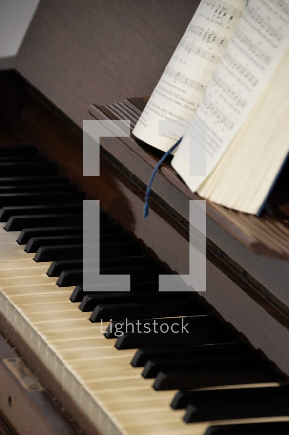 Piano up close with open songbook. 
