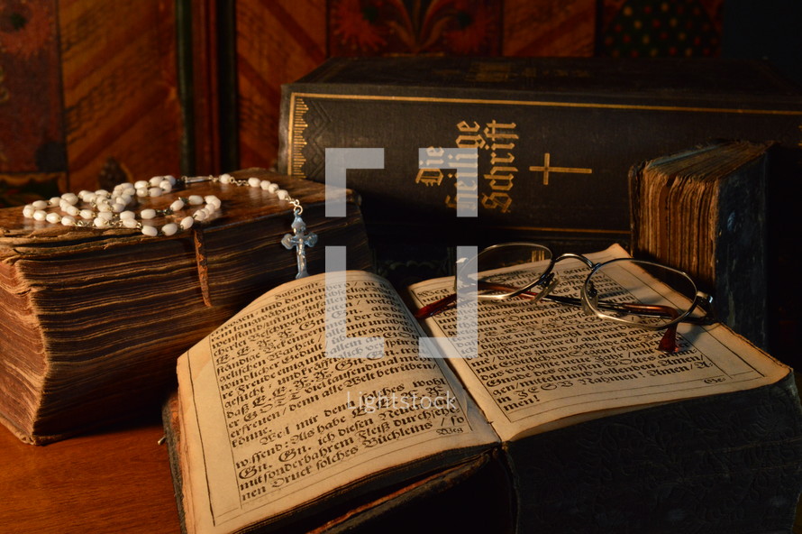 rosary and reading glasses on an old Bible 