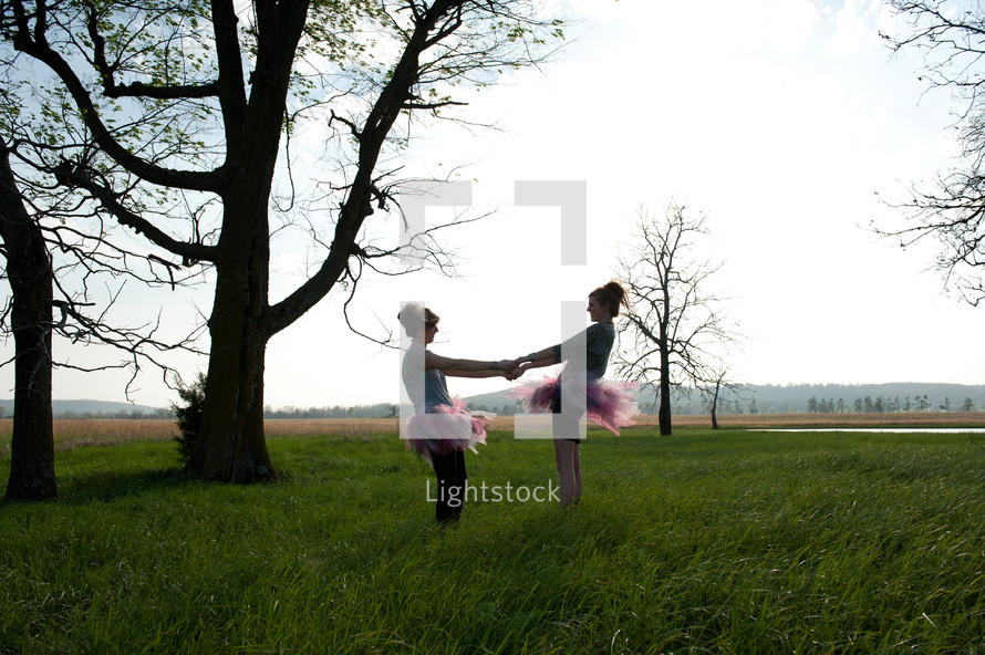 mother and daughter dancing in tutus outdoors 