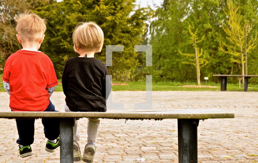 toddler boys sitting on a bench 