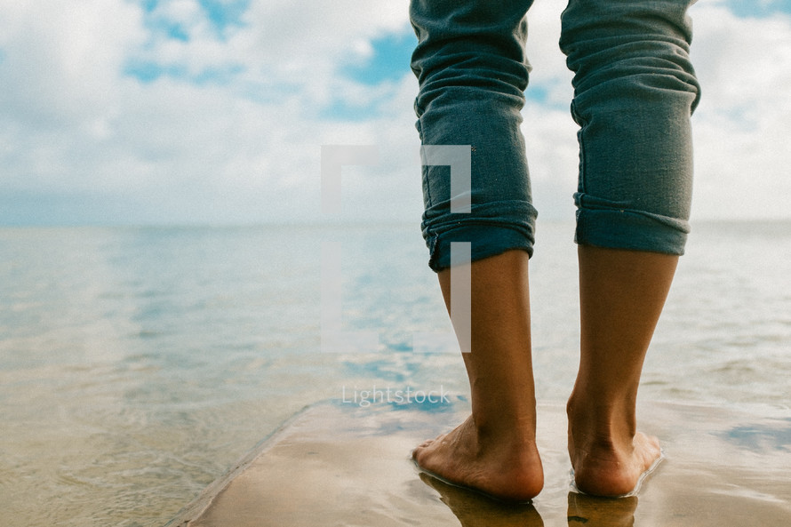 bare feet stadning in shallow water 