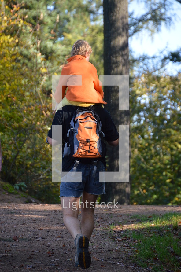 toddler boy riding of his father's shoulder 