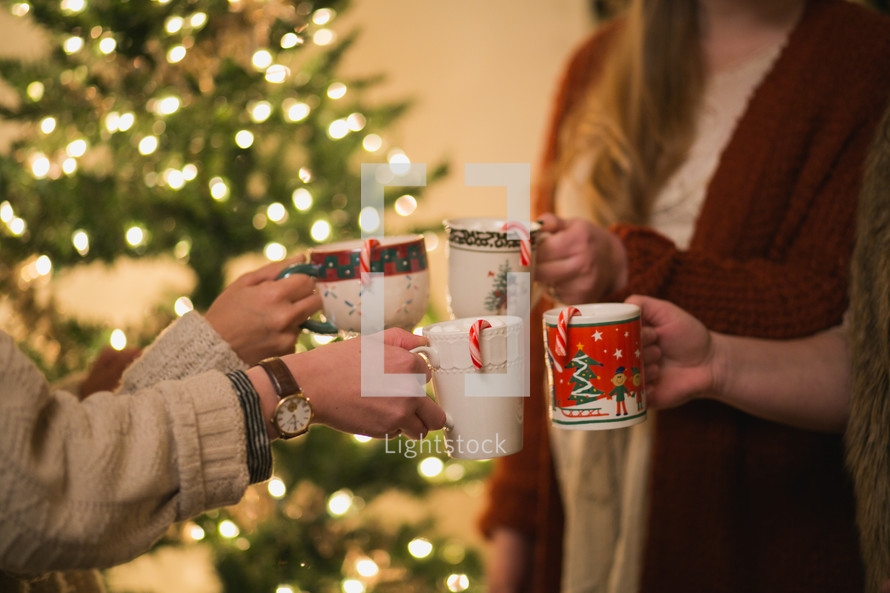 Four women put their Christmas cups together in a toast.