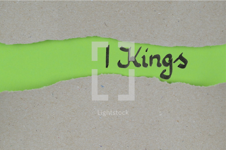 Title 1 Kings - torn open kraft paper over green paper with the name of the book 1 Kings
