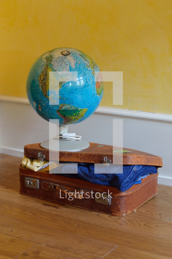 a globe on a stuffed suitcase 