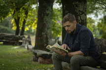 Man reading on a bench in the park