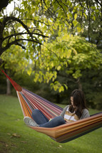 Woman in a hammock reading 