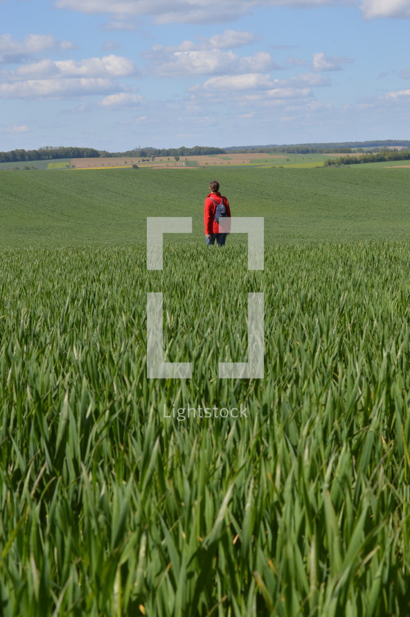 person standing in a green field 