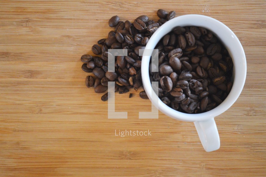 overhead view of a coffee cup filled with coffee beans 