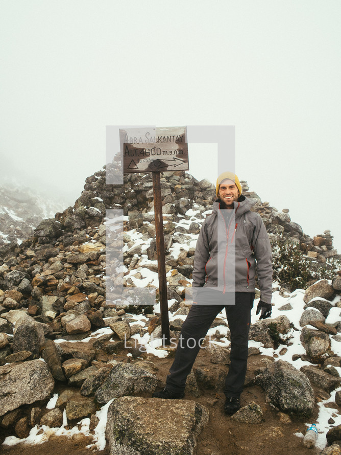 woman standing at the top of a mountain peak