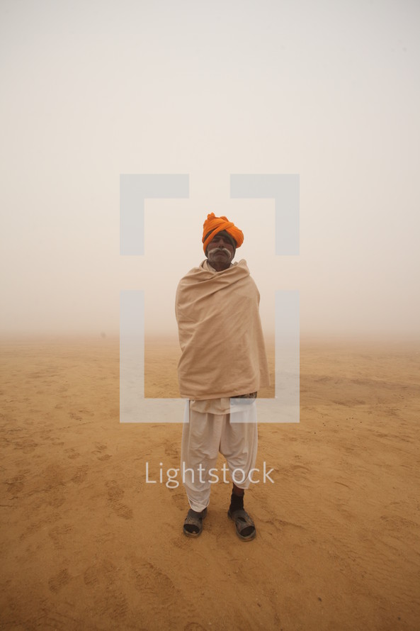 man standing in a desert during a dust storm