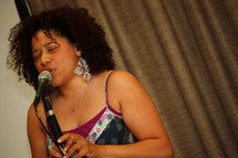 woman singing into a microphone 