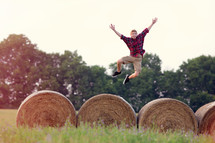 man jumping on hay bales 
