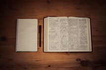 blank notebook, pen, and open Bible 