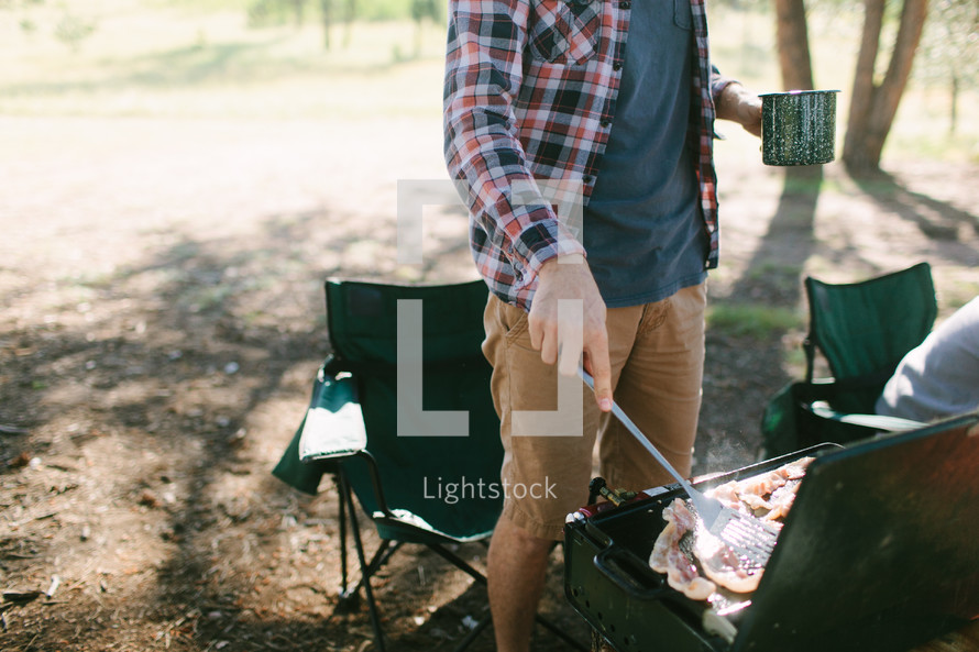 a man cooking breakfast at a campsite 