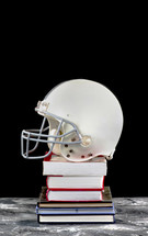 football helmet on a stack of books 
