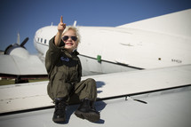 a boy child sitting on an airplane in a pilot uniform