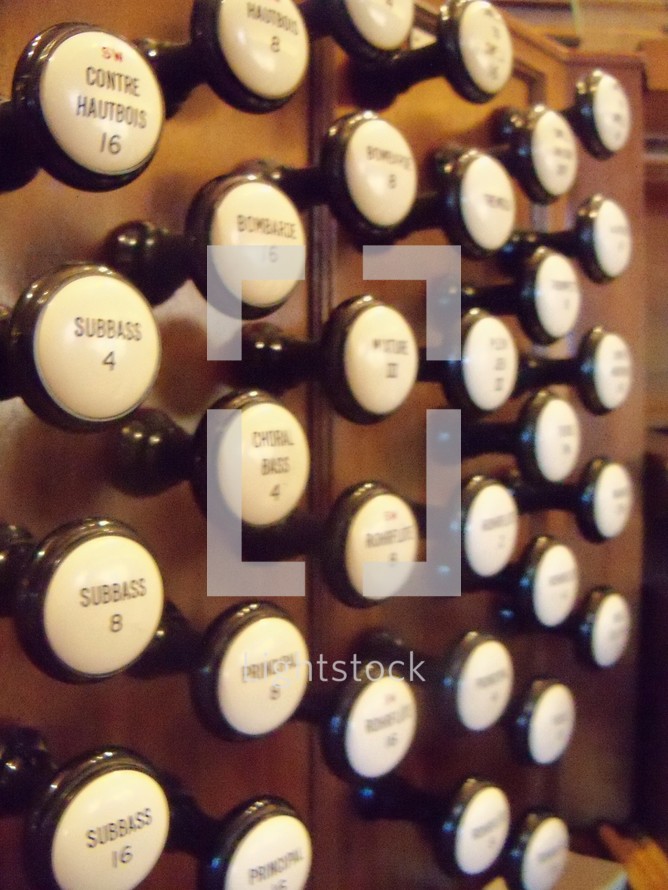 organ knobs that belong to an old pipe organ in a traditional worship church service. 