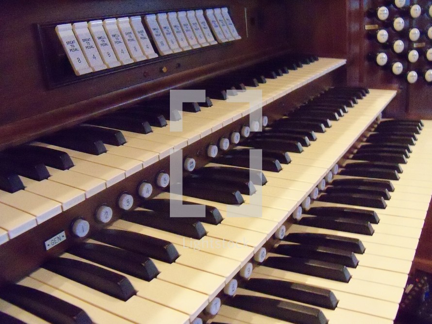 organ keys belonging to an old pipe organ in a church sanctuary.