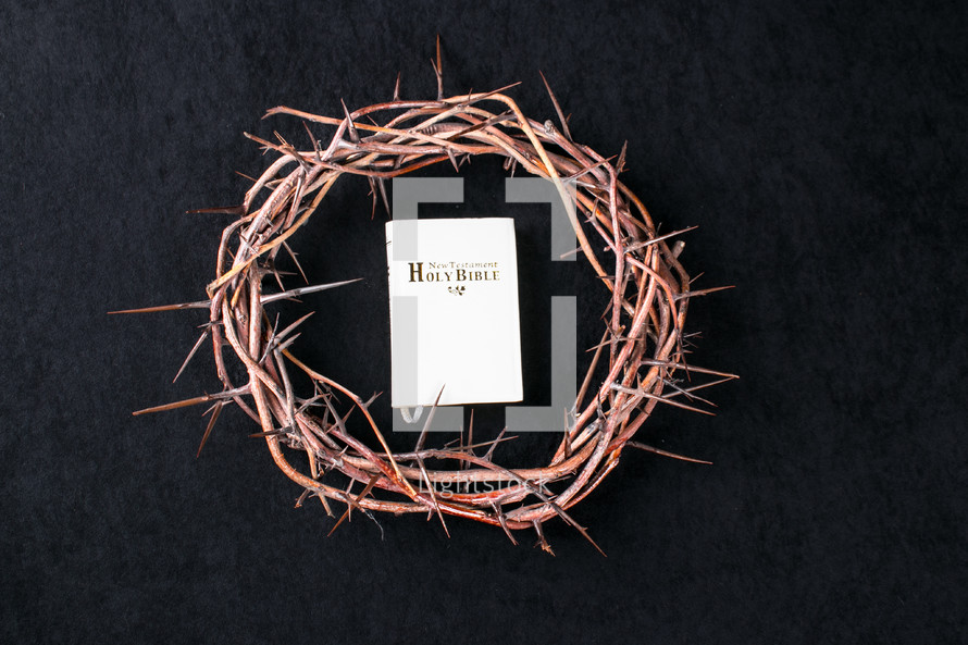 Bible and crown of thorns on a black background 