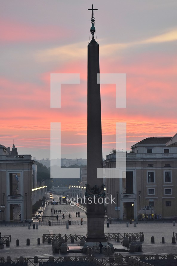 tower with cross in a courtyard at sunset 